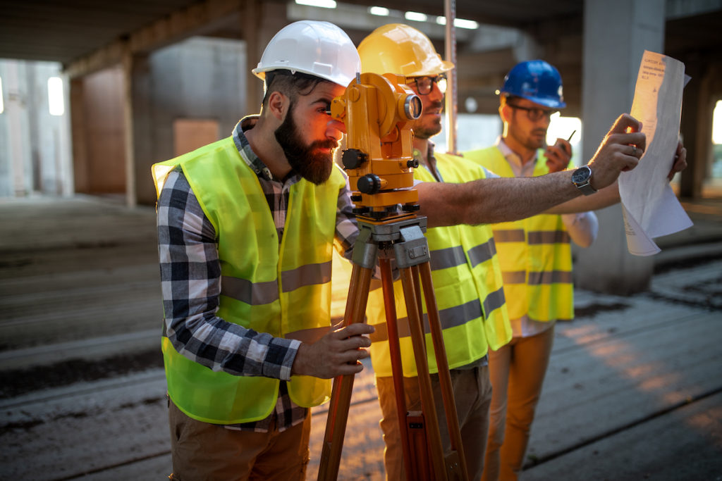 Engineer surveyor working with theodolite at construction site