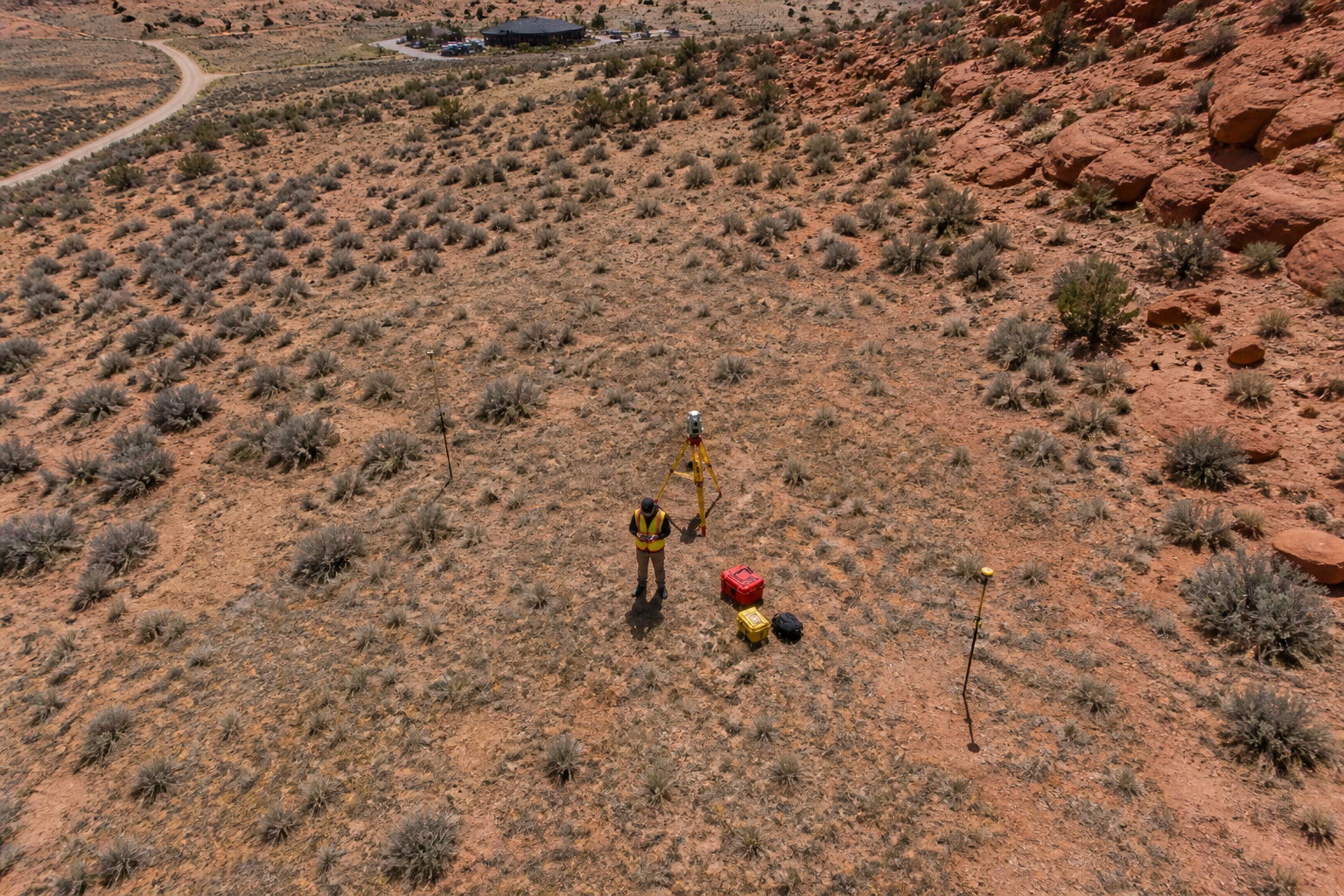What Are the 7 Types of Surveys? Aerial view of a land surveyor using survey equipment on an open Utah property showing different types of surveys in action